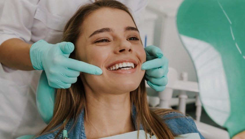 Young woman smiling while visiting her dentist in Windham