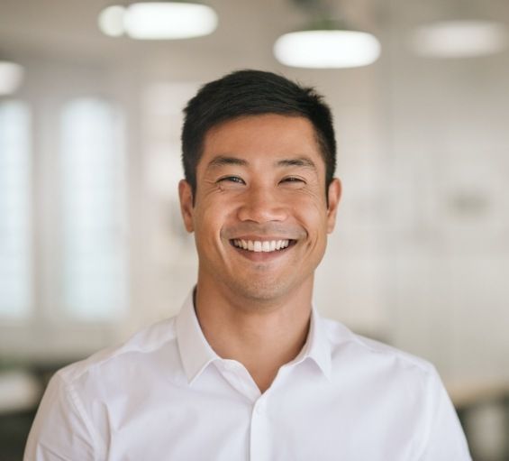 Man in white collared shirt grinning after preventive dentistry