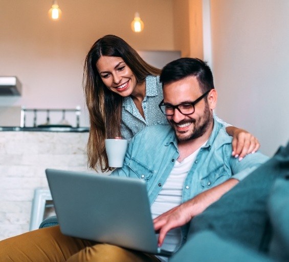 Man and woman looking on laptop for dentist reviews in Windham