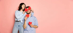 Happy couple holding paper hearts